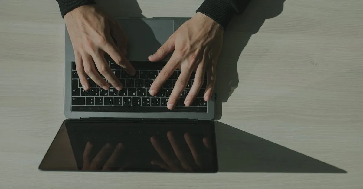 Overhead view of hands typing on a laptop keyboard