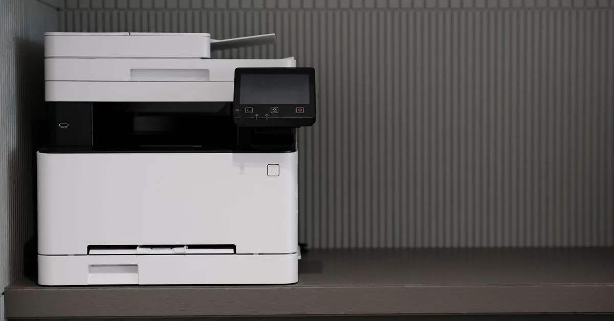 An office multifunction printer and scanner beside a desk